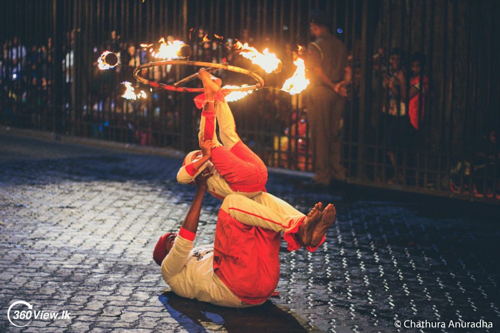 Fire Ball Dancers perform along a street during the Kandy Esala Perahera